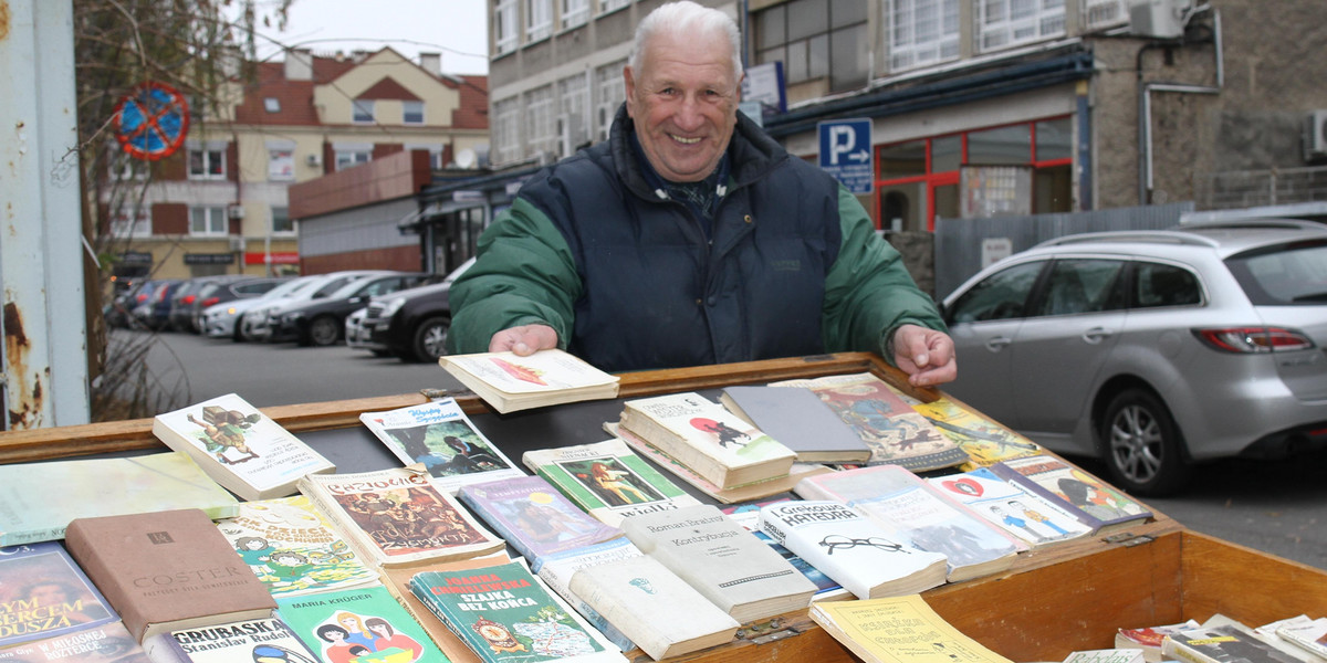 Pan Marian Gajos rozdaje przechodniom używane książki