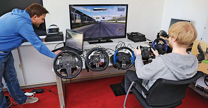 Dwaj profesjonalni gracze wyścigowi Patrick Seitz (po lewej) i Henrik Stoldt przetestowali dla Komputer Świata pięć kierownic na aktualnych grach wyścigowych: Dirt Rally, Project Cars i F1 2016. Sprawdzili montaż i uruchomienie oraz ergonomię, czułość i dostępność poszczególnych komponentów. Wykorzystali dostarczone w komplecie z urządzeniami mocowania do stołu i na wykładzinie, czyli w warunkach bardzo zbliżonych do tych występujących w wielu domach.