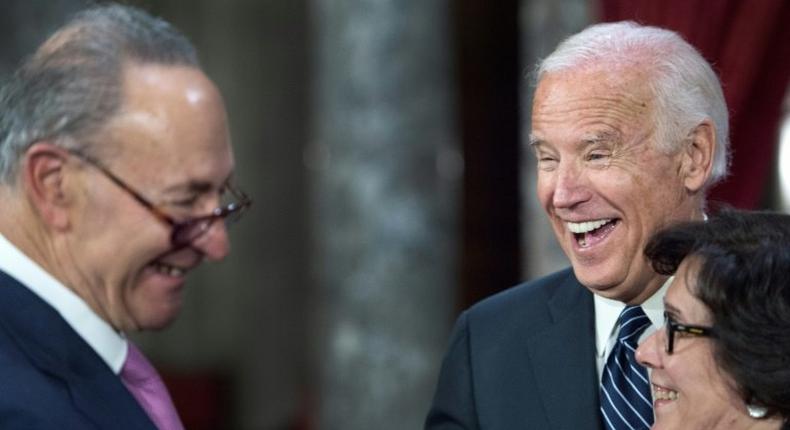 US Senator Charles Schumer, US Vice-President Joe Biden(R) and Iris Schumer laugh during a reenacted swearing-in in Washington, DC