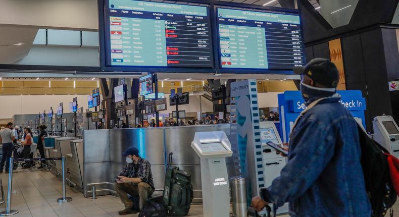 A passenger looks at an electronic flight notice board displaying cancelled flights at Tambo International Airport in Johannesburg on November 27, 2021, after several countries banned flights from South Africa following the discovery of a new coronavirus variant Omicron.