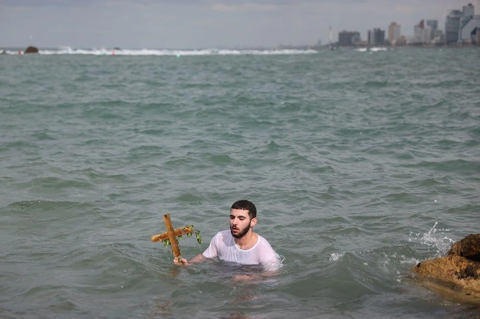 Hrišćanski vernik iz grčke pravoslavne crkve Arhangela Mihaila drži krst nakon što ga je izvukao iz Sredozemnog mora tokom proslave Bogojavljanja u Staroj luci Jafa u Tel Avivu, Izrael, 19. januara 2026. | Foto: ABIR SULTAN/EPA/Shutterstock
