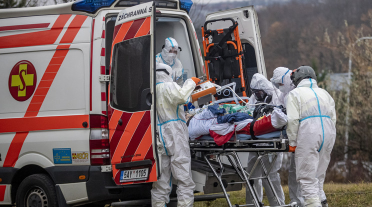 Védőruházatot viselő egészségügyi alkalmazottak egy helikopterrel szállított koronavírussal fertőzött beteget visznek kórházba Prágában 2021. november 25-én, a koronavírus-járvány negyedik hulláma idején / Fotó: MTI/EPA/Martin Divisek