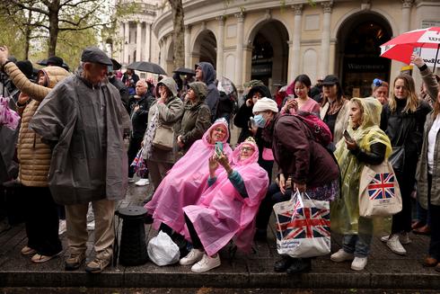 Pomimo deszczu nie odpuszczają. Brytyjczycy wciąż oblegają londyńskie ulice. (fot. PAP)
