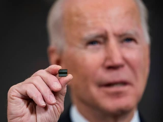 Prezydent USA Joe Biden trzymający w palcach półprzewodnik, w czasie przemówienia na temat problemów w amerykańskiej branży motoryzacyjnej