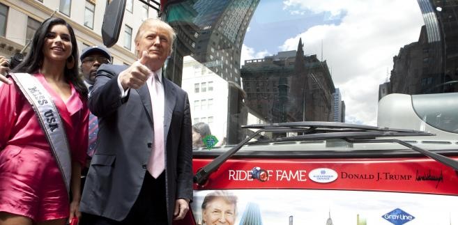 Donald Trump, miliarder z branży nieruchomości, prezentuje autobus ze swoją podobizną. Obok stoi Rima Fakih, Miss USA 2010.