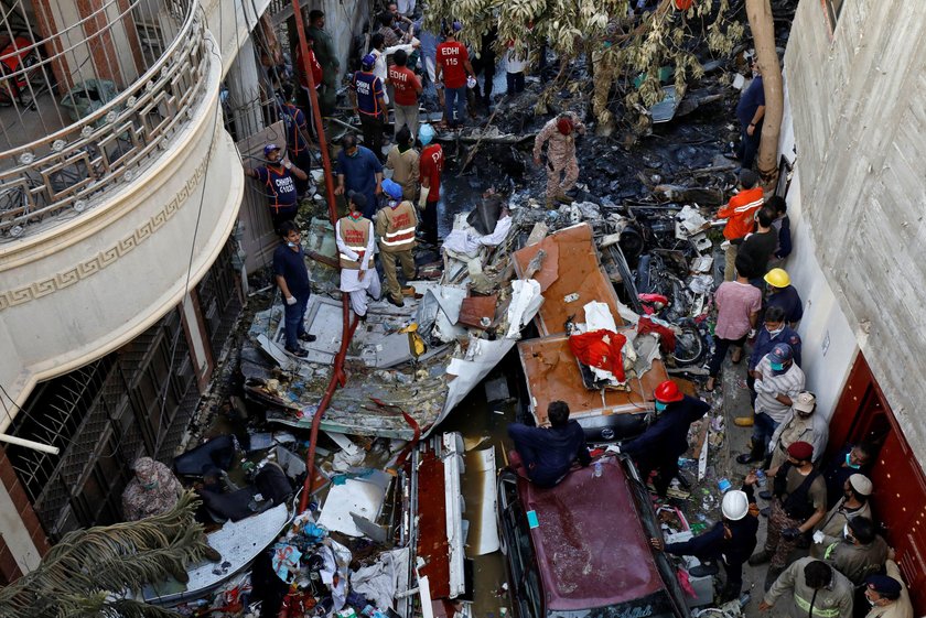 Rescue workers gather at the site of a passenger plane crash in a residential area near an airport i