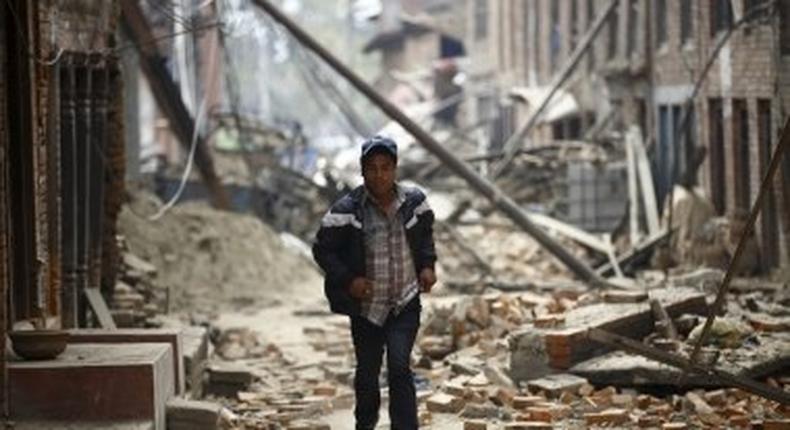 A man runs through ruins as aftershocks hit Kathmandu.