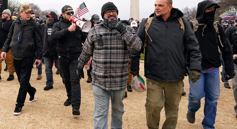 In this Jan. 6, 2021, photo, Proud Boys including Joseph Biggs, center in flannel jacket, walk toward the U.S. Capitol in Washington, in support of President Donald Trump.