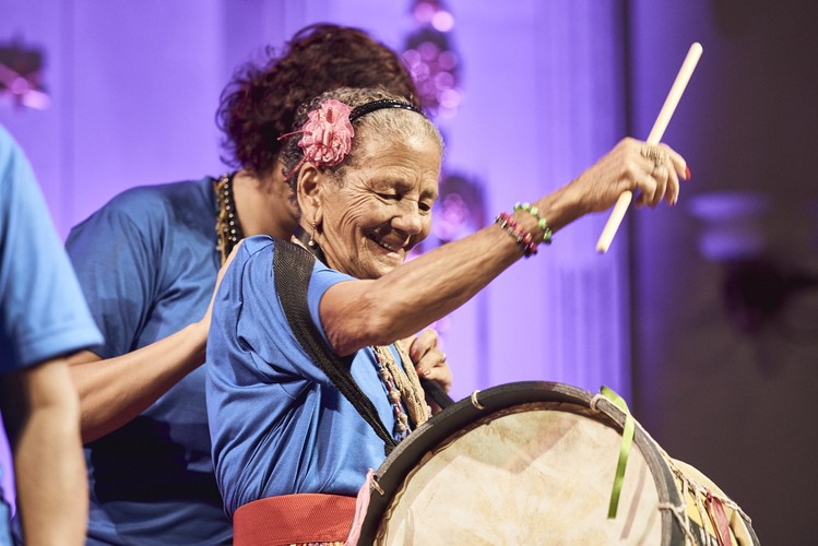 <strong>Meninas de Sinha - brazylijski głos</strong>
<br></br>
Nadzwyczaj żywiołowa atmosfera panowała na występie Meninas de Sinha, grupy brazylijskich śpiewaczek. Publiczność wspólnie z artystkami wypełniły Synagogę Pod Białym Bocianem niezwykłą energią.
<br></br>
Natomiast po występie Los Paveros por la Tierra publiczność wychodziła mocno poruszona. Kolumbijczycy zaśpiewali i opowiedzieli o swojej walce, toczonej tylko przy pomocy muzyki, z koncernami bezprawnie i przemocą odbierającymi im ziemię, by umieścić tam plantacje palm olejowych. Przedstawienie uzupełniały sugestywne fragmenty dokumentu nakręconego w Las Pavas, z udziałem artystów. Całość mocno przemawiała do wyobraźni.
<br></br>
fot. Mateusz Bral