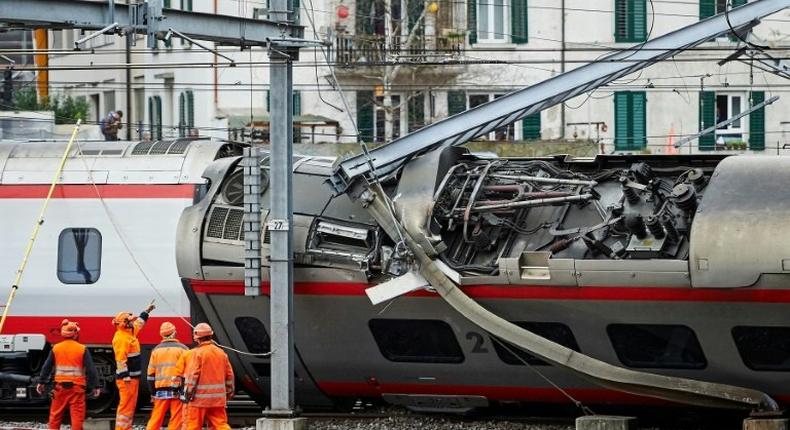 Police officers and workers inspect the site of a train crash at the train station of Lucerne where a Eurocity train of Trenitalia derailed on March 22, 2017 in Lucerne