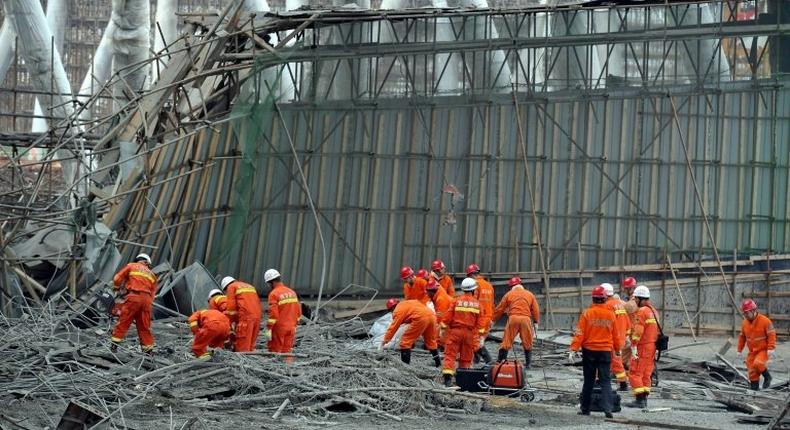 Workers search for survivors in the debris of a collapsed platform in a cooling tower at a power station at Fengcheng, in China's Jiangxi province, on November 24, 2016