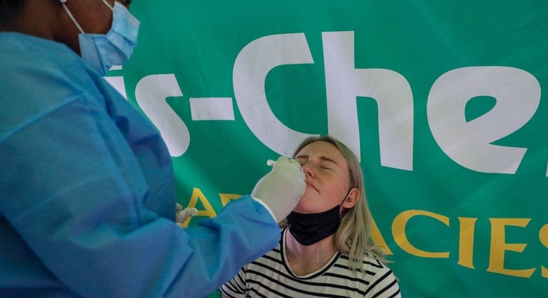 A healthcare worker conducts a COVID-19 test on a traveler at OR Tambo International Airport in Johannesburg on November 28, 2021.