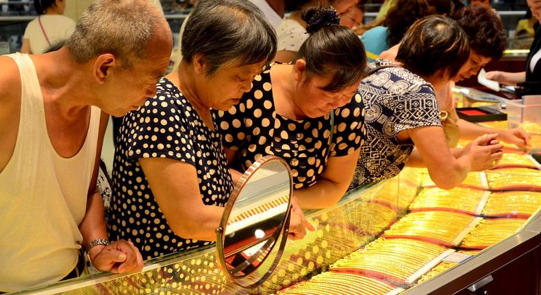 Customers look at gold necklaces at a jewelry store in Xuchang, Henan province, August 12, 2015. Gold rose for a fifth session in a row on Wednesday, hitting a fresh three-week high as the dollar and European equities slid on concerns over China's devaluation of its currency.Reuters