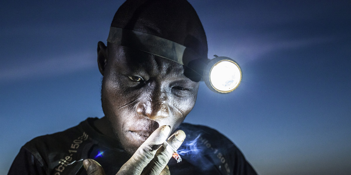 A mine worker takes a smoke break before going back into the pit. Miners in Bani face harsh conditions and exposure to toxic chemicals and heavy metals.