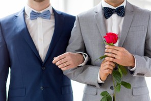 close up of happy male gay couple holding hands