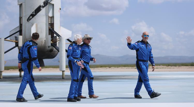 Jeff Bezos és három társa az űrből való visszaérkezés után, a Blue Origin űrrepülő előtt