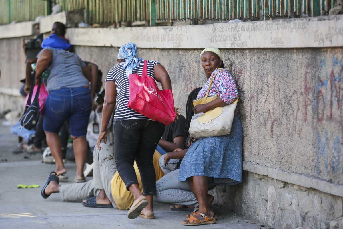 Njerëzit vrapojnë për t'u mbrojtur ndërsa bandat përleshen me policinë në Port-au-Prince, Haiti, 1 Mars