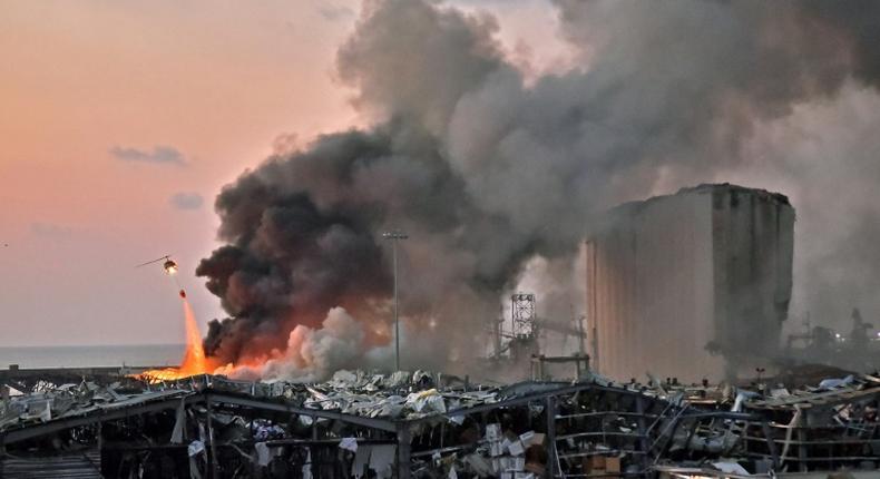 A helicopter pours water onto the fire at the port of Lebanon's capital Beirut