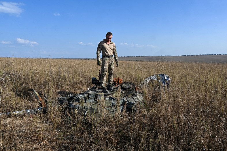 Mężczyzna na zniszczonym rosyjskim czołgu w obwodzie charkowskim