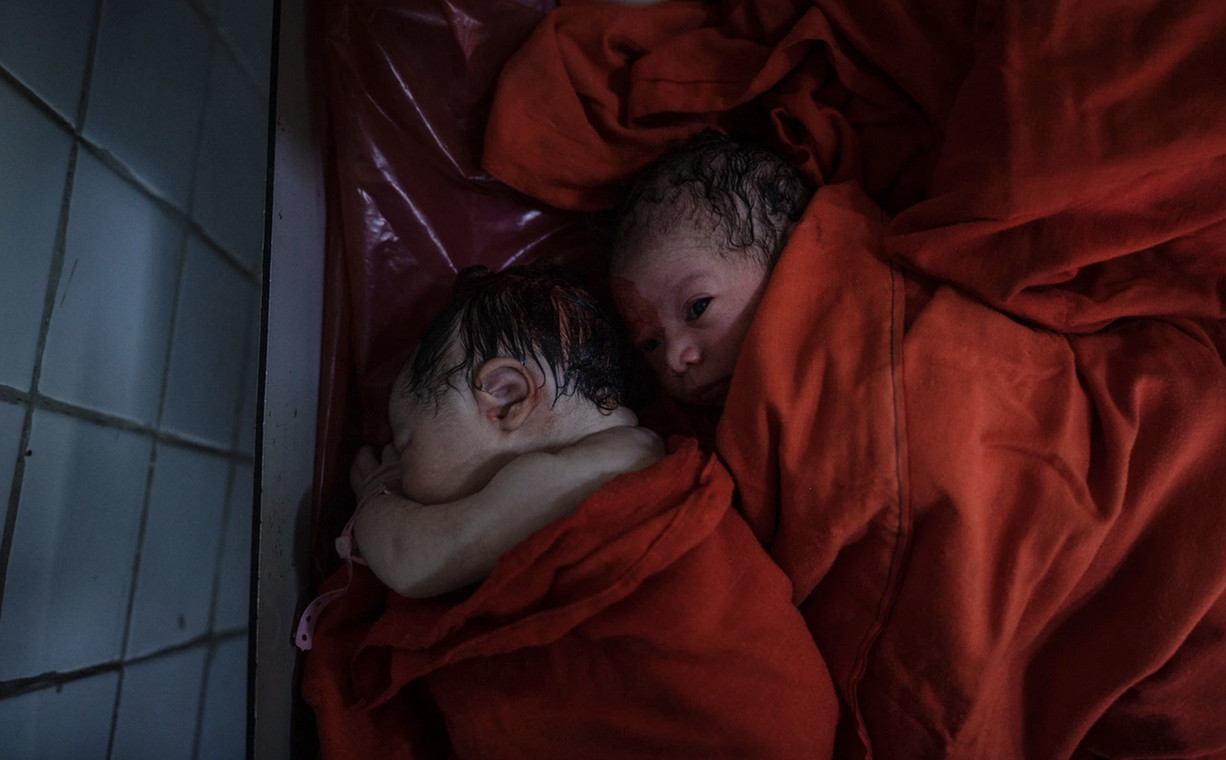 Dziewczynka i chłopiec urodzeni w klinice w Kabulu w odstępie kilku minut od siebie. To ich matki na zdjęciu wyżej trzymają się za ręce podczas porodu 