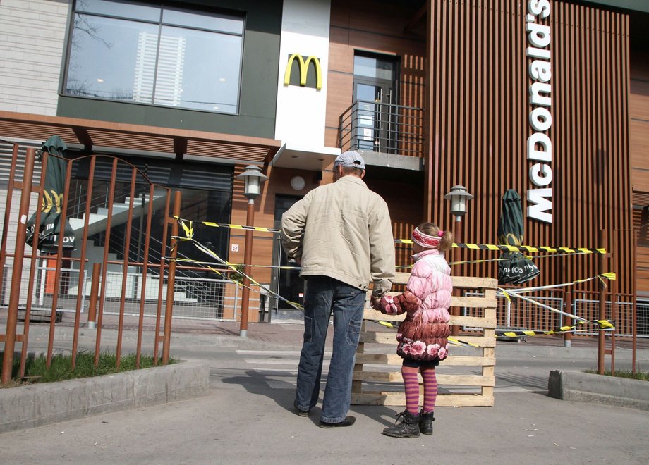 Mężczyzna i dziewczynka patrzą na zamkniętą restaurację McDonald's w stolicy Krymu, Simferopolu, 4 kwietnia 2014 r.