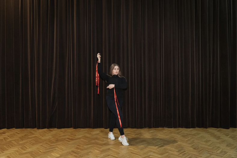 Dziewczyna ćwiczy ruchy taneczne przed wyjściem na scenę podczas festiwalu kultury białoruskiej w Polsce, 3 lutego 2023 r.