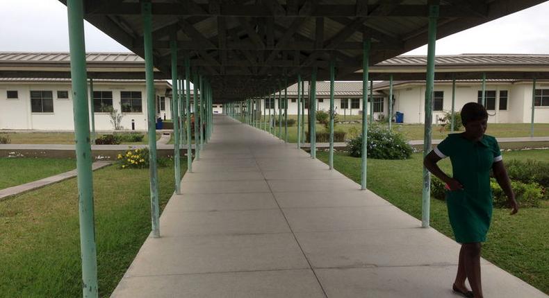 A lone nurse walks through Winneba Trauma and Specialist Hospital in Winneba, Ghana, August 20, 2015. Doctors in Ghana will suspend a three-week strike they called to press for better conditions of service, the Ghana Medical Association (GMA) said on August 21. The 125-bed hospital is almost empty because of a partial strike by doctors who have withdrawn emergency and out-patient services to press for better pay and conditions. Picture taken August 20, 2015.  REUTERS/Matthew Mpoke Bigg