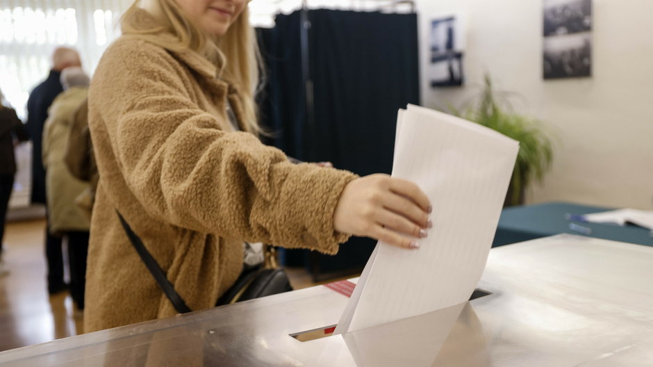 Kobieta przy urnie wyborczej