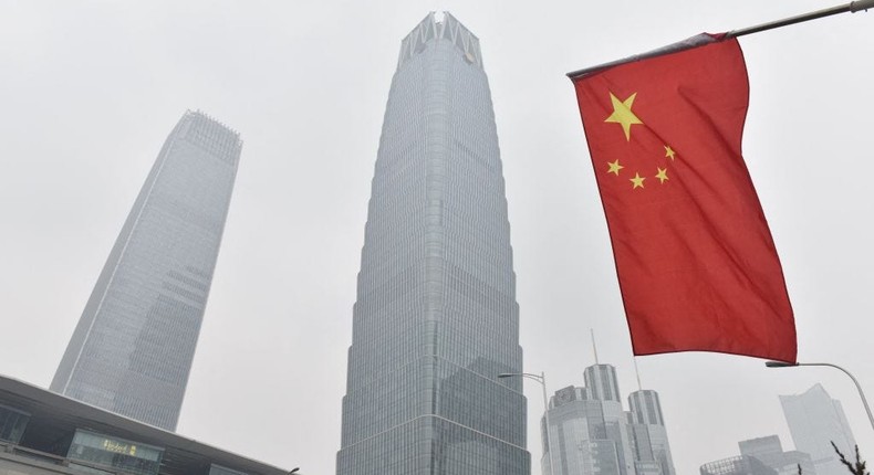 A Chinese flag flies near buildings in the central business district on a polluted day in Beijing on February 27, 2018.GREG BAKER via Getty Images