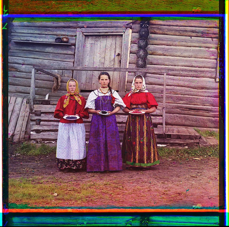 Three young women offer berries to visitors to their izba, a traditional wooden house, in a rural area along the Sheksna River, near the town of Kirillov.