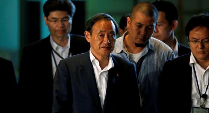 Japan's Chief Cabinet Secretary Yoshihide Suga (C) arrives at Prime Minister Shinzo Abe's official residence in Tokyo, Japan, July 2, 2016, following news of an attack on a restaurant in the Bangladeshi capital by gunmen. 