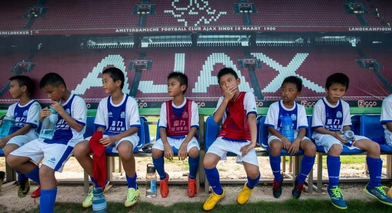 Children rest after a training session at the Guangzhou R&F Football Academy in Meizhou in southern China