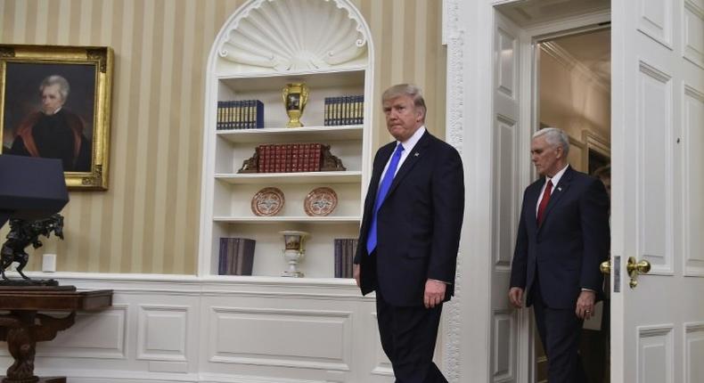 US President Donald Trump and Vice President Mike Pence walk into the Oval Office at the White House