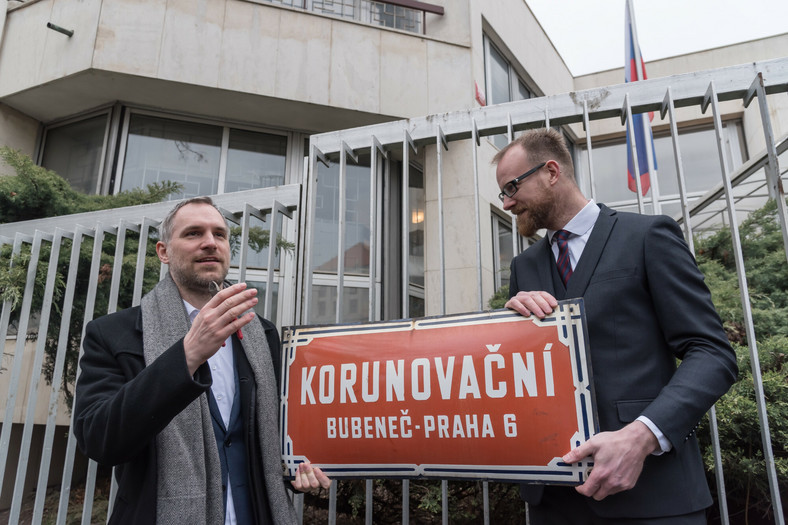 Burmistrz Pragi Zdenek Hrib usuwający stary znak przed ambasadą rosyjską podczas ceremonii zmiany nazwy ulicy — na ulicę „Bohaterów Ukrainy”.