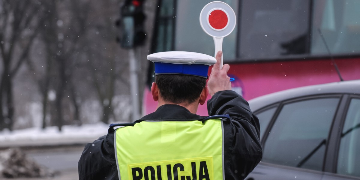 Policjant zatrzymuje samochód.