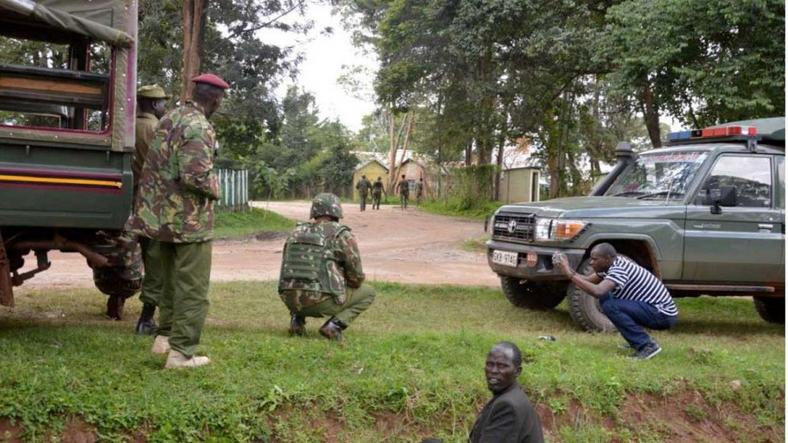 Kenyan police officers hold their position during the deadly shooting at the Kapenguria police station.  