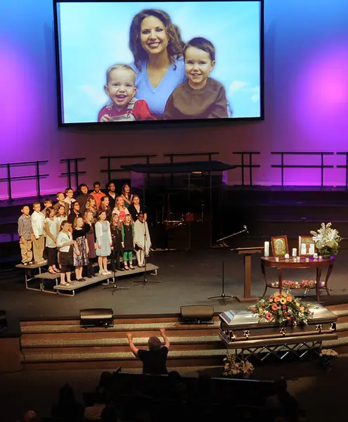 Zdjęcie Susan Cox Powell i jej synów Charliego (po prawej) i Bradena (po lewej) wyświetlane, gdy chór dziecięcy występuje podczas pogrzebu Charliego i Bradena Powellów w Life Center Church w Tacoma w stanie Waszyngton w sobotę 11 lutego 2012 r. . 5-letni Braden i 7-letni Charlie zostali zabici przez swojego ojca, Josha Powella, 5 lutego 2012 r. / Lui Kit Wong / Tacoma News Tribune / Tribune News Service via Getty Images