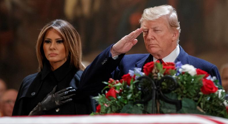President Donald Trump with the first lady, Melania Trump, near the casket containing the body of former US President George H.W. Bush in the Rotunda of the US Capitol.