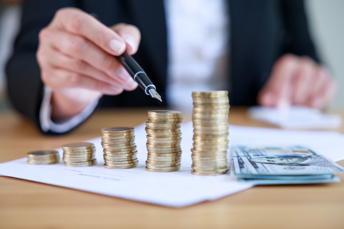 banknoty i monety ułożone w słupki przypominające wykres