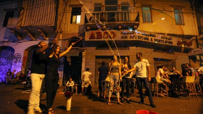 People react to a giant soap bubble during a music festival in Mar Mikhael area in Beirut