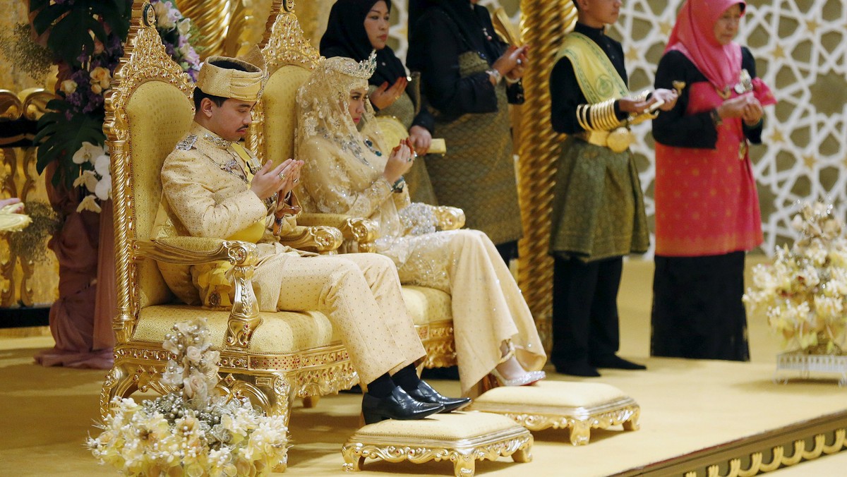 Brunei's newly wed royal couple, Prince Abdul Malik and Dayangku Raabi'atul 'Adawiyyah Pengiran Haji Bolkiah, pray during the enthronement ceremony at their wedding in the Nurul Iman Palace in Bandar Seri Begawan