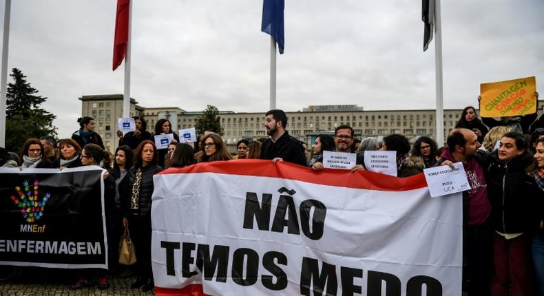 Striking nurses in Portugal, shown here holding a banner reading We Are Not Afraid, want higher wages, more overtime pay and an end to a freeze on promotions