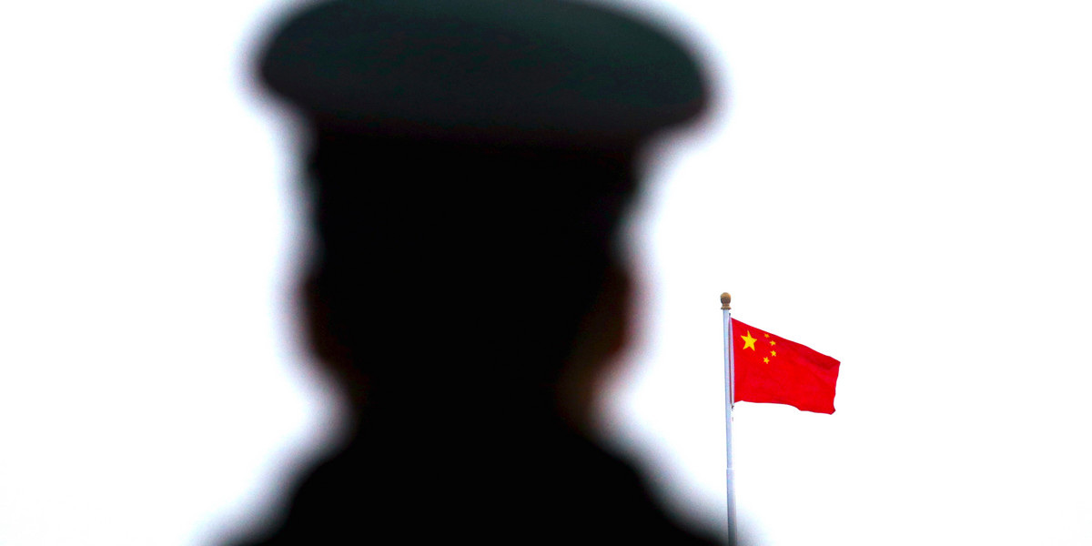 A paramilitary policeman watches a flag-raising ceremony at Tiananmen Square ahead of the opening session of the National People's Congress (NPC) in Beijing, China, March 5, 2016.