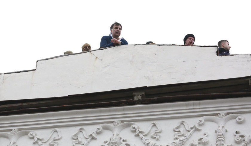 Supporters of Georgian former President Mikheil Saakashvili break a window a police car carrying Saa