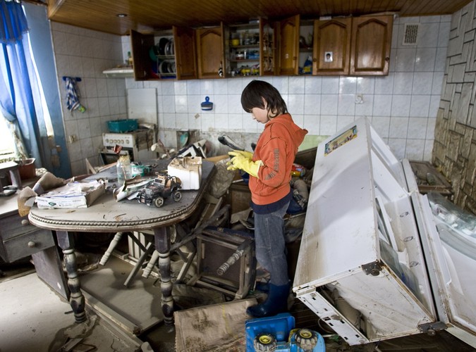 Krystian Sierpiński ogląda swoje zabawki w zniszczonym przez powódź mieszkaniu we wsi Wilków (woj. lubelskie)