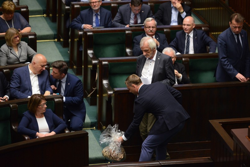 Poseł PO Sławomir Nitras (P) z workiem trocin, który wręczył politykom PiS w Sejmie