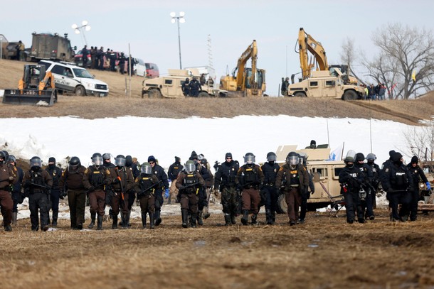 Law enforcement officers advance into the main opposition camp against the Dakota Access oil pipelin