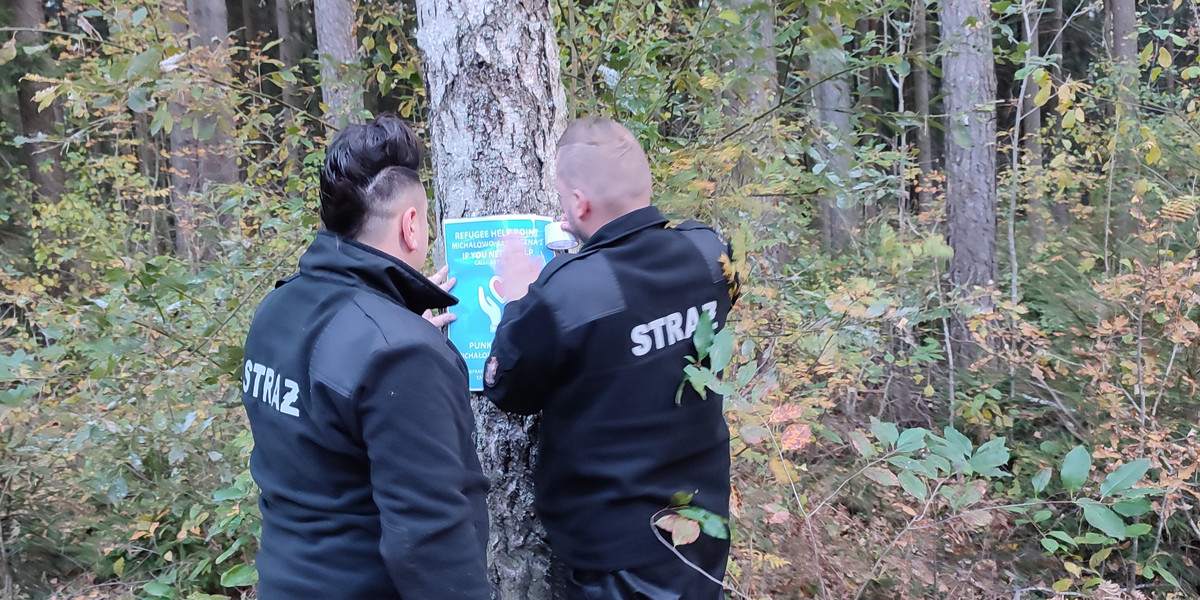 Strażacy z Michałowa rozwieszają po lasach plakaty z informacją o pomocy dla migrantów. 