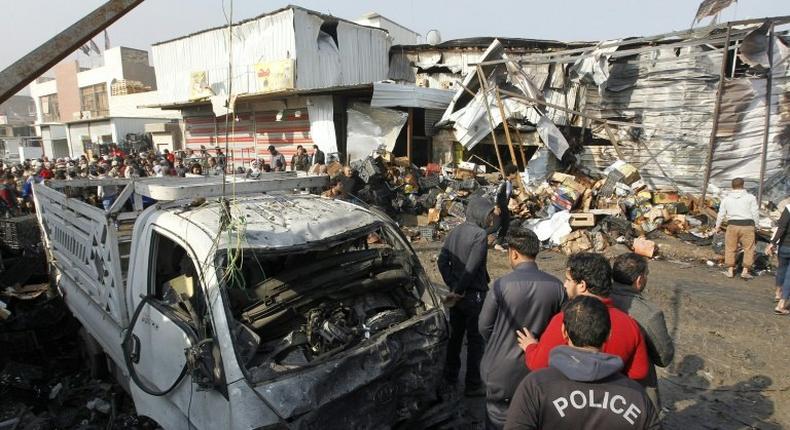 Iraqis inspect the site of an attack at Baghdad's main vegetable market on January 8, 2017