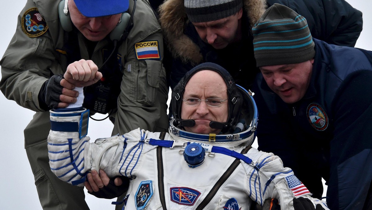 Ground personnel help U.S. astronaut Scott Kelly to get out of a Soyuz capsule shortly after landing